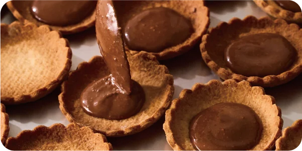 タルトにナッツチョコレートを流し込む様子